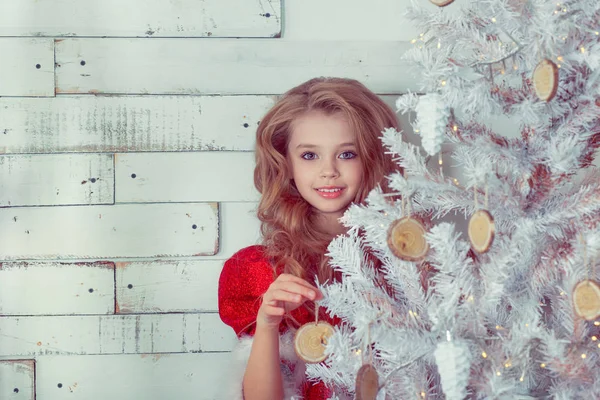 Närbild av barn hängande dekorativa leksak på vit julgran gren — Stockfoto