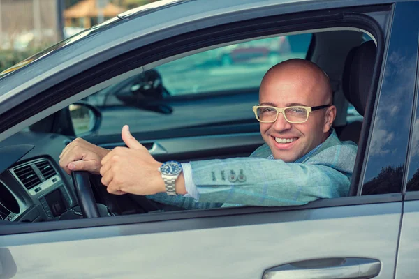 Hombre de negocios en su coche sonriendo, mostrando los pulgares hacia arriba — Foto de Stock