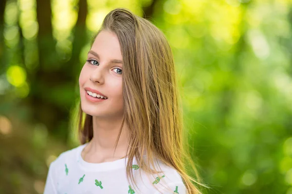 Mujer sonriendo con una sonrisa perfecta y dientes blancos en un parque y mirando a Camer — Foto de Stock