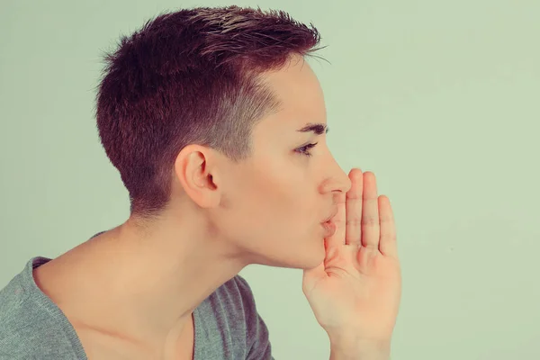 Close-up van een vrouw vertellen van een geheim houden van de hand in de buurt van mond geheimhouding gebaar geïsoleerde groene achtergrond muur. Afbeelding van horizontale studio opname — Stockfoto