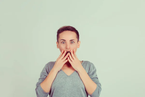 Erstaunt schaut eine schockierte Frau in die Kamerahände auf der grünen Wand mit offenem Mund. Körpersprache menschliche Emotion Gesichtsausdruck Studio Aufnahme horizontales Bild — Stockfoto