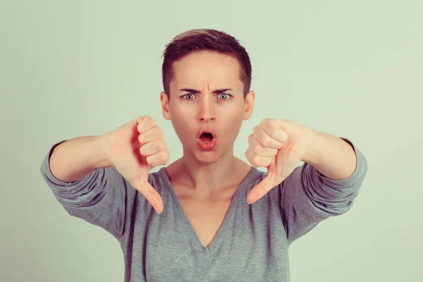 Vrouw met duim omlaag gebaar geïsoleerde groene achtergrond muur. Studio schoot horizontale afbeelding. Lichaamstaal, menselijke emotie ace expressie — Stockfoto