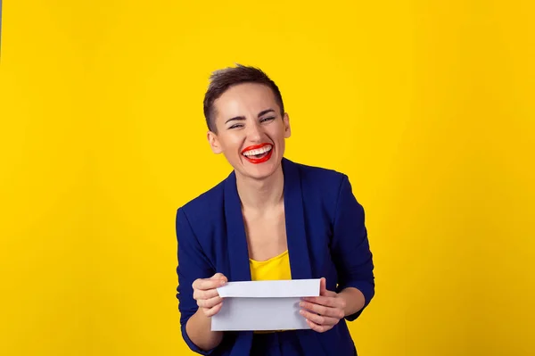 Mujer feliz sonriendo sosteniendo carta sobre aislada pared de fondo amarillo. Expresión facial positiva emoción humana lenguaje corporal —  Fotos de Stock