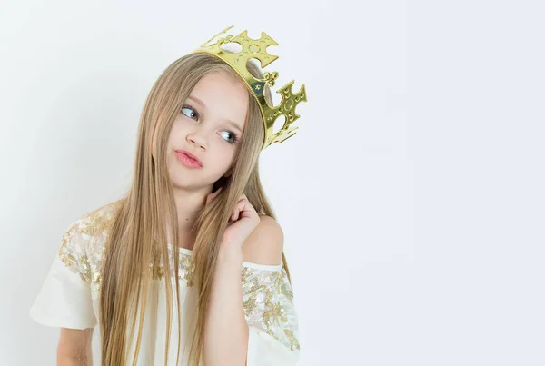 Mini señorita. Joven chica aburrida con una corona y un vestido blanco en vacaciones mirando hacia un lado aislado fondo blanco — Foto de Stock