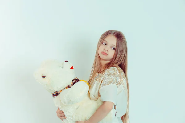 De cerca retrato de una linda chica aburrida triste molesto sosteniendo oso de peluche sobre fondo verde blanco aislado . — Foto de Stock