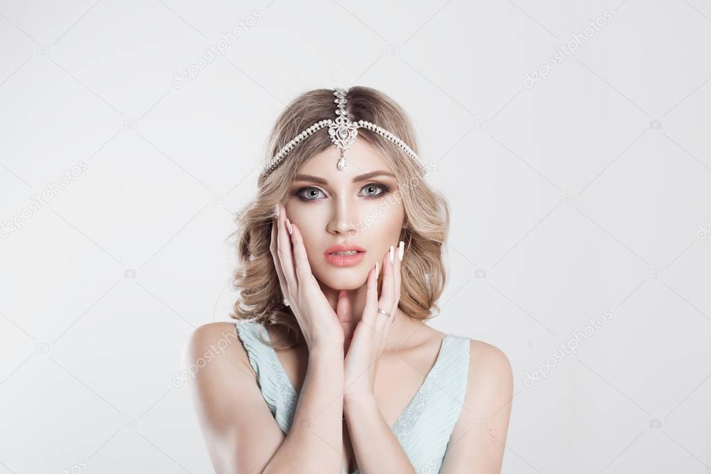 Beauty Queen bride woman with bright pink with tikka indian jewelry on head hands near her cheek looking at you camera,  light bridal makeup isolated grey white background wall