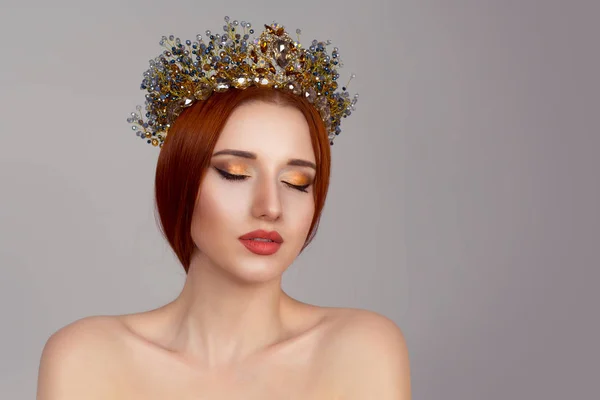 Hermosa chica en una corona dorada sobre fondo gris, ojos cerrados —  Fotos de Stock