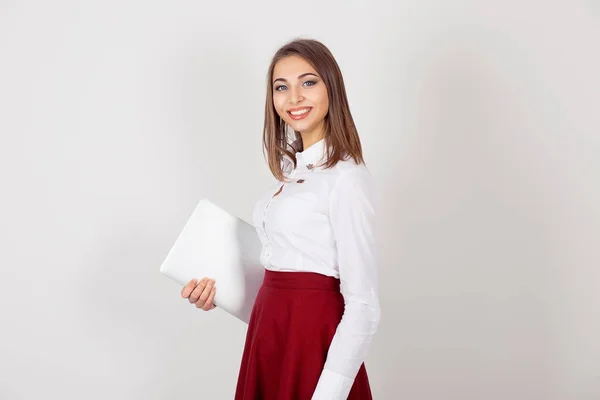 Audaz y exitoso. Chica sonriente sosteniendo el portátil blanco mirando a la cámara. Una sola persona. Fondo de pared blanco aislado. Ropa de negocios, expresión facial de emoción humana positiva. Copiar espacio . —  Fotos de Stock