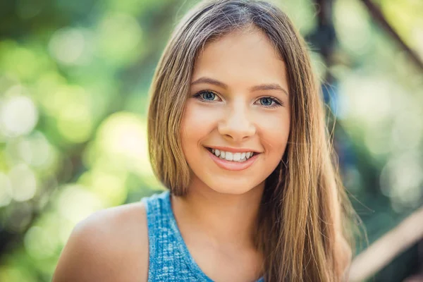 Mujer sonriendo con una sonrisa perfecta y dientes blancos en un parque y mirando a Camer — Foto de Stock