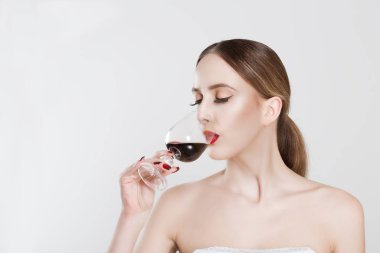 Sommelier. Güzel genç kadın ile zevk bardak kırmızı şarap, kapalı gözler, beyaz duvar arka plan üzerinde izole içme. İnsan yüzü ifadesi, vücut dili. Burun sommelier kavramı