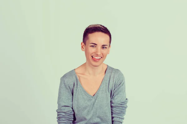 Porträt einer glücklichen jungen Frau, die die Zunge klebt und dich ansieht, Kameramädchen mit dunklen langen Haaren, isoliert hellgrünem Wandhintergrund — Stockfoto