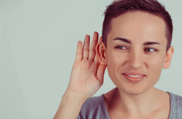 Closeup head shot macro face young nosy woman hand to ear gesture carefully intently secretly listening juicy gossip conversation news isolated green gray wall background Human face expression emotion — Stock Photo, Image