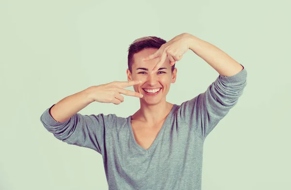 Retrato encantadora mujer feliz que muestra la victoria o signo de paz gesto aislado sobre fondo de pared gris verde. Expresión facial positiva emoción lenguaje corporal — Foto de Stock