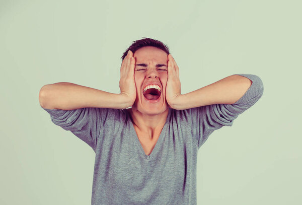 Стрессовая сердитая женщина, кричащая, имеет вспышку гнева изолированный светло-зеленый серый фон. Отрицательная реакция на эмоции человека
