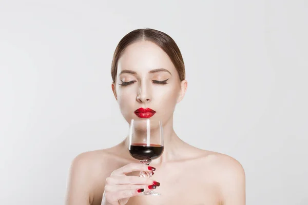 Сомелье. Красивая молодая женщина, нюхающая аромат питья с удовольствием бокал красного вина, закрытые глаза на изолированном белом фоне. Удовольствие выражение лица, язык тела. Концепция сомелье носа — стоковое фото