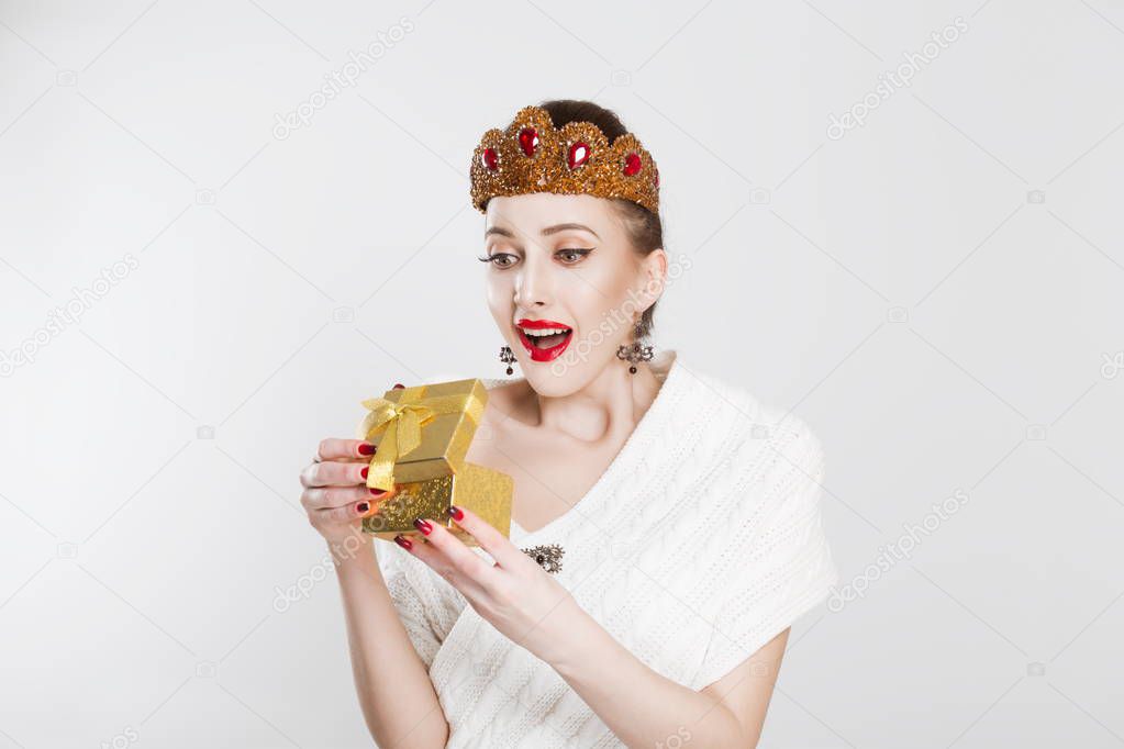Happy excited woman beauty pageant contestant holding gift / present. Cute surprised mixed Asian Chinese / Caucasian female model.