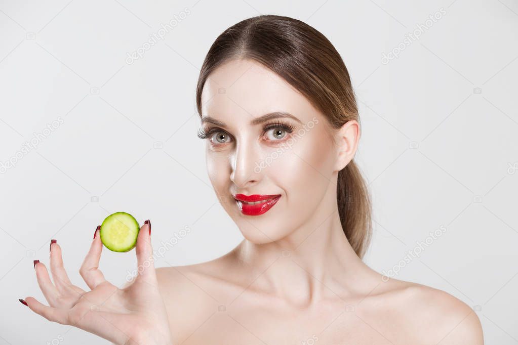 My mask is tasty. Woman showing cucumber slice looking at you camera smiling isolated white background