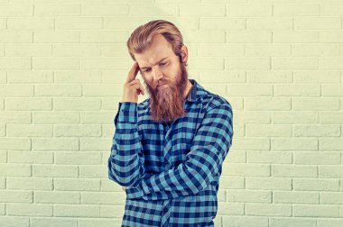 Düşünme. Wards bakacak bir endişe adam rahat mavi gömlekli adam portresi beyaz tuğla duvar arka plan izole. Sarı Toned yatay görüntü. İnsani duygular, yüz ifade negatif