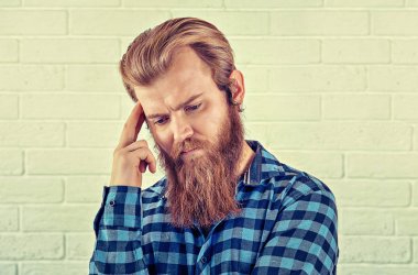 Düşünme. Wards bakacak bir endişe adam rahat mavi gömlekli adam portresi beyaz tuğla duvar arka plan izole. Sarı Toned yatay görüntü. İnsani duygular, yüz ifade negatif