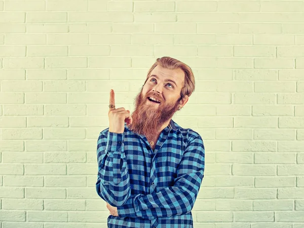 Retrato de un hombre de camisa azul casual sonriente apuntando con el dedo hacia arriba i — Foto de Stock