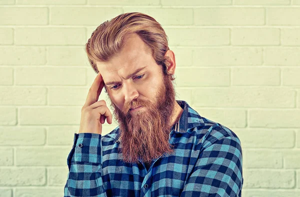 Düşünme. Wards bakacak bir endişe adam rahat mavi gömlekli adam portresi beyaz tuğla duvar arka plan izole. Sarı Toned yatay görüntü. İnsani duygular, yüz ifade negatif