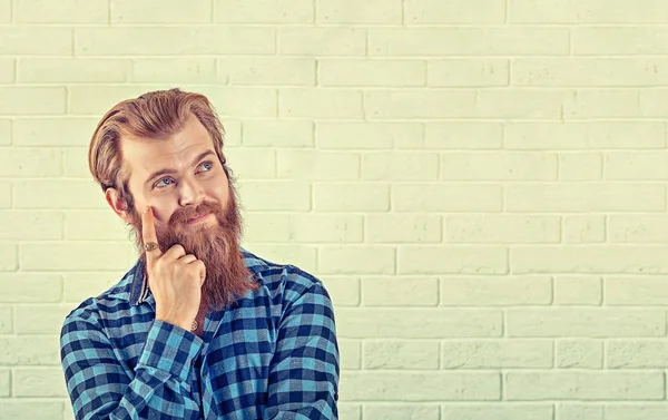 Daydream. Yanak izole düşünme beyaz tuğla duvar arka taraftan bakılması gülmek gülümseyen rahat mavi gömlekli adam portresi. Sarı Toned yatay görüntü. Olumlu insan duygu, yüz ifade