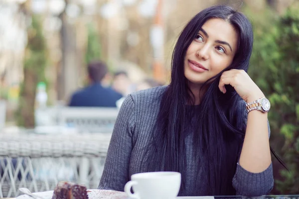 Daydreaming on a coffee break. Pensive happy woman remembering looking at side up sitting on a terrace of bar coffee shop restaurant hoping thinking of love blurred man in the green nature background — Stock Photo, Image