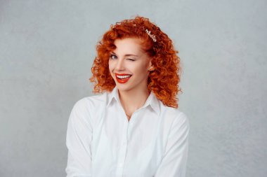Başarılı bir iş kadını. Portre portre baş shot seksi güzel kendine güvenen Kızıl saçlı kıvırcık kız izole gri arka plan duvar göz kırpıyor. Olumlu insan duygu yüz ifade duygu yaşam algı