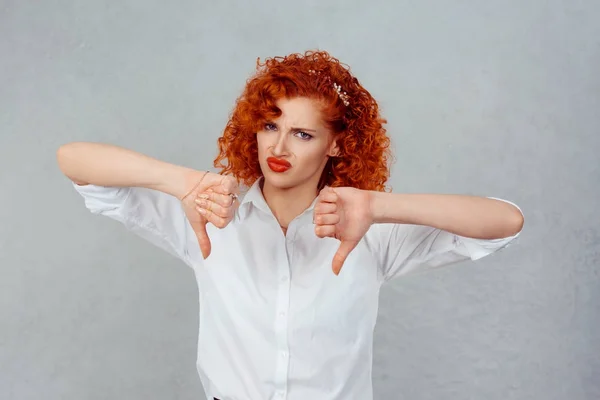 I dislike. Closeup portrait of unhappy angry mad pissed off redhead curly woman annoyed wife giving thumbs down gesture looking with negative facial expression and disapproval isolated gray background — Stock Photo, Image