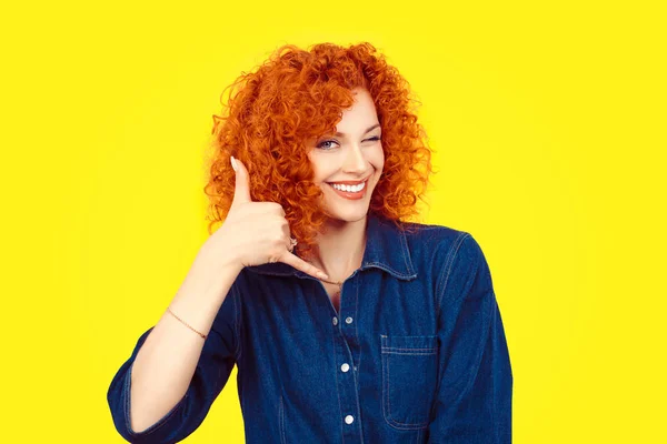 Give me a call. Closeup portrait young red head curly single woman excited happy student winking with eye making showing call me gesture sign with hand shaped like phone isolated yellow background. — Stock Photo, Image