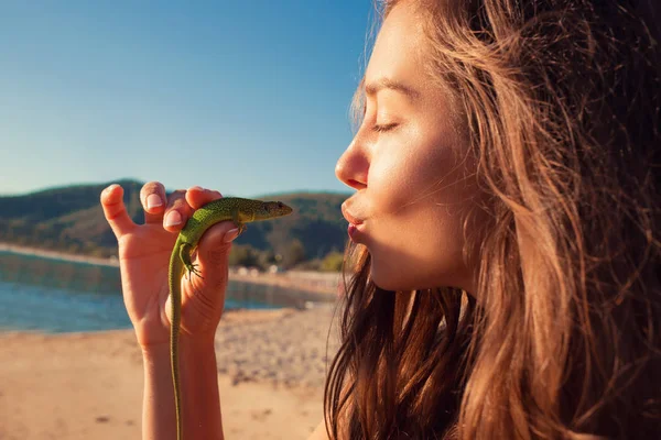 Love for animals. Woman kissing lizard — Stock Photo, Image