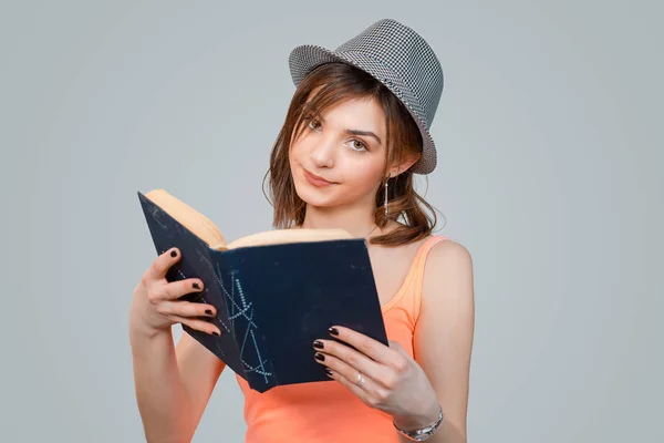 Mulher cética segurando um livro olhando para você câmera ceticamente — Fotografia de Stock