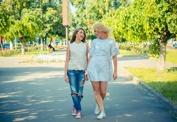 Mother and daughter walking holding hands in the park