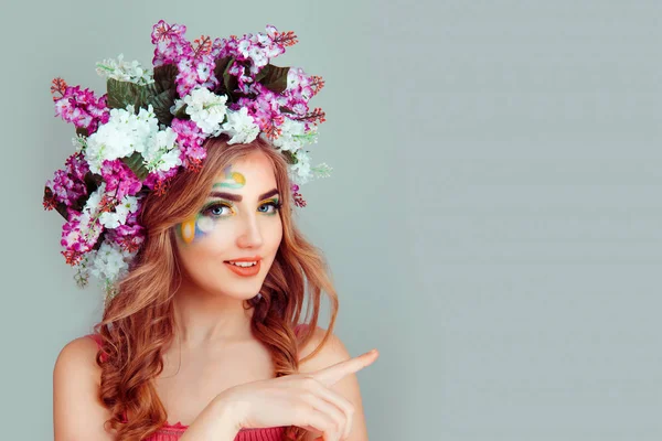 Feliz bela jovem com headband lilás floral mostra um dedo apontando — Fotografia de Stock