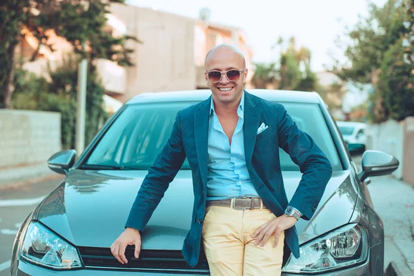 Uomo in piedi vicino alla sua auto di fronte alla sua casa sorridente felice — Foto Stock
