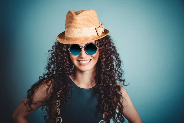 Женщина в соломенной шляпе и синих солнцезащитных очках улыбается — стоковое фото