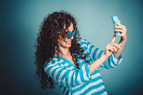 Mulher fazendo selfie com smartphone isloated no fundo azul — Fotografia de Stock