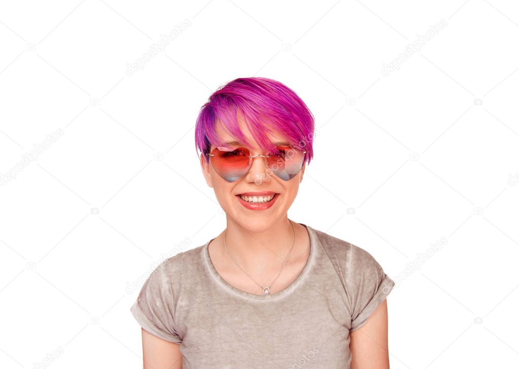Woman model in trendy pink heart shaped sunglasses, has good mood laughing happily