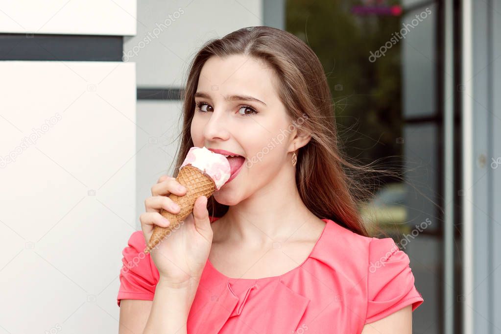 Happy girl eating ice cream outdoors near store.