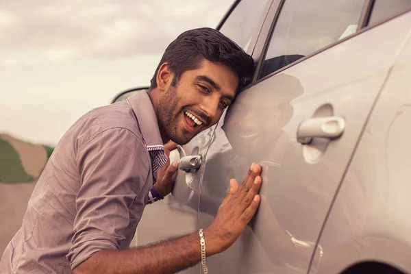 Joven hispano vistiendo camisa formal sosteniendo está acariciando su coche — Foto de Stock