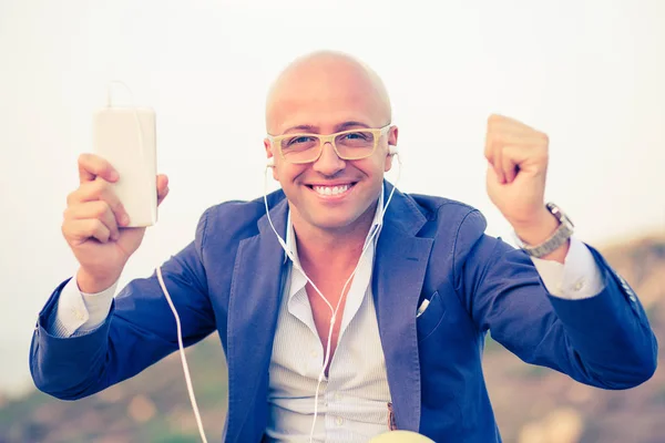 Hombre feliz con teléfono y auriculares — Foto de Stock