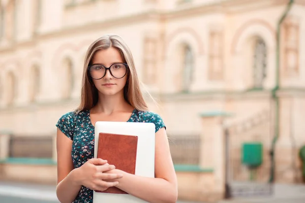 女人认真的 特写肖像学生妇女持有书籍 笔记本电脑看着你的自信相机站在户外大学背景多文化模式混合种族亚洲俄罗斯女孩 — 图库照片