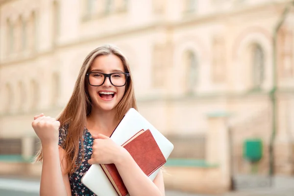幸運な学生 クローズ アップ肖像画幸せな若い女幸せ Exults の大学の背景に建物屋外で立って笑っている恍惚としたあなたを見てポンプの拳 成功終了研究概念を祝う — ストック写真
