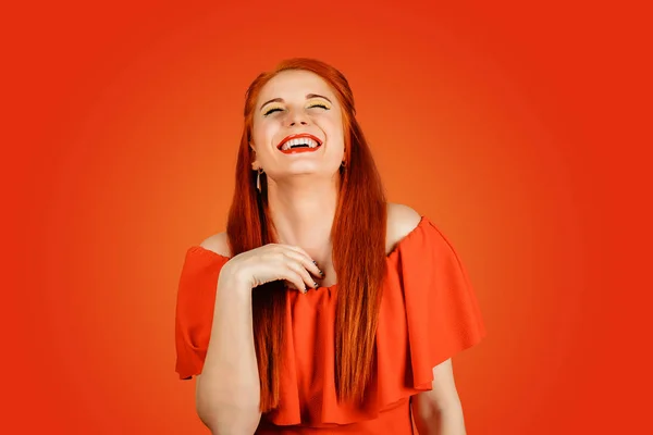 Mooie lachende jonge vrouw met rood haar heeft veel plezier, geïsoleerd op rode achtergrond — Stockfoto