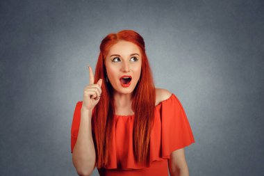 Attractive woman pointing her finger up has an idea.