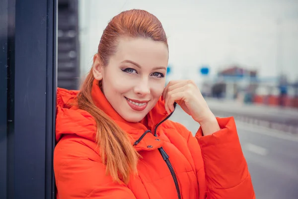 redhead woman outdoors smiling.