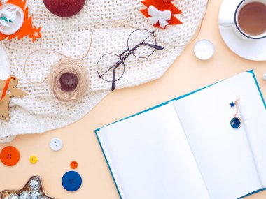 Boş defter kağıdıyla Noel kadını masası. Şeftali rengi arka planda Noel süsleme işyeri. Kadınsı blog yazarı kış çalışma alanı. Düz yatış, üst manzara, düz yatış, 2020 Yeni Yıl