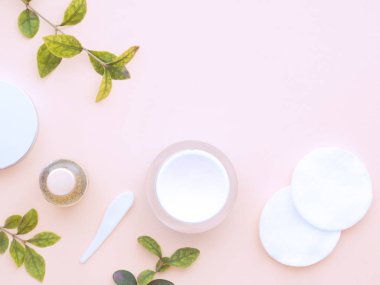 Taze yeşil yapraklar, doğal kozmetik ürünler, vücut jeli ya da sıvı el yapımı sabun, pamuk pedler ve pastel pembe arka planda izole edilmiş yüz kremi. Düz konum, üst görünüm, kopyalama alanı