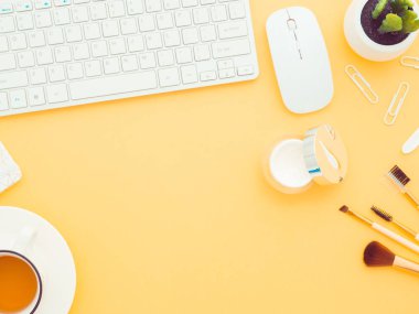 Doğal kozmetik ürünlerini internetten sipariş et. Taze yeşil bitki yaprakları, pamuk pedler, vücut jeli sabun, yüz kremi ve sarı arkaplanda izole edilmiş bir klavye. Düz görünüm kopyalama alanı