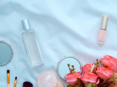 Gül çiçekleri klavye makyaj aletleri ve fırçalar, parfüm, ayna, pudra şişesi tırnak cilası şişesi beyaz çarşaflar üzerinde arka plan olarak kopyalama alanı. Düz konum, dergiler, sosyal medya, Üst görünüm